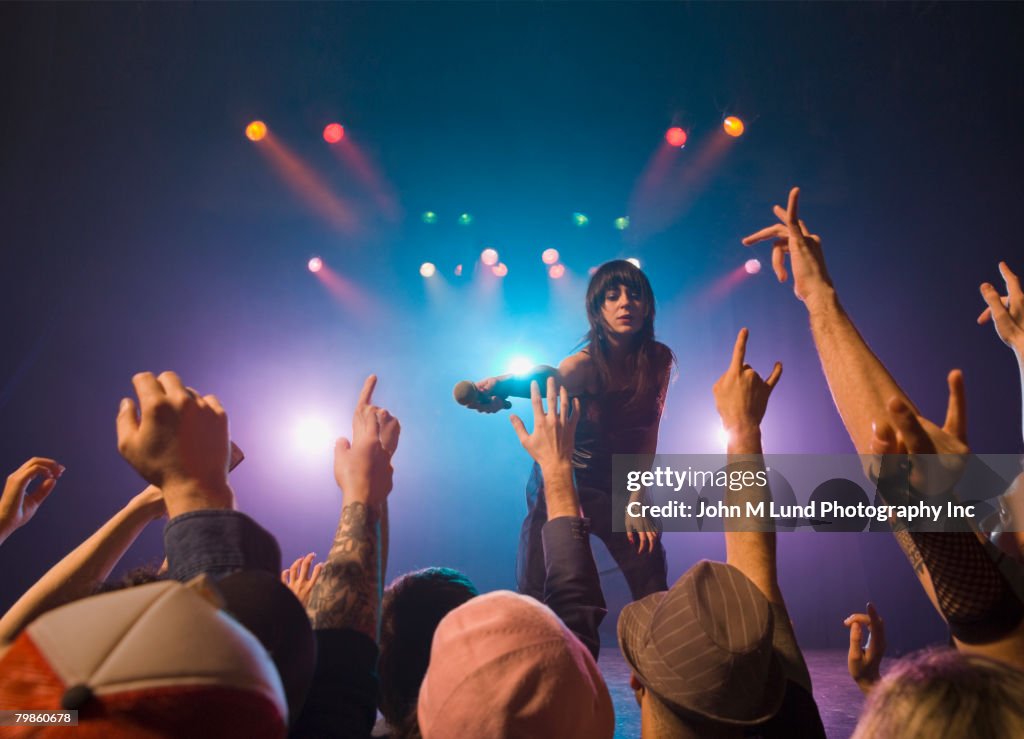 Female rock star on stage interacting with audience