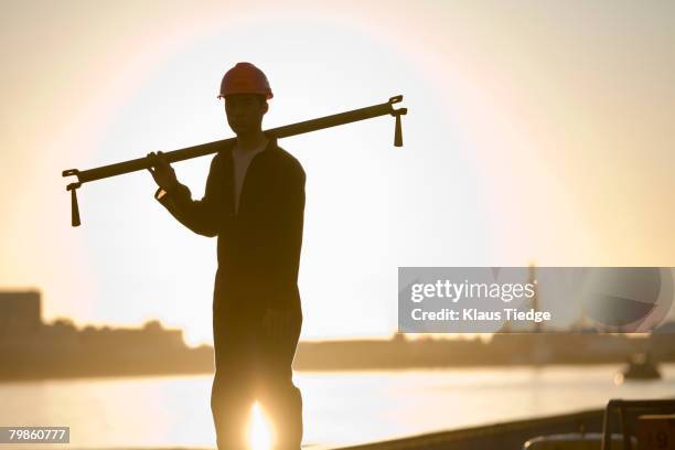 asian male dock worker holding pipe - global mindset stock pictures, royalty-free photos & images