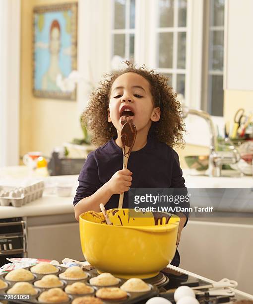 african girl eating cupcake batter - girls licking girls stockfoto's en -beelden
