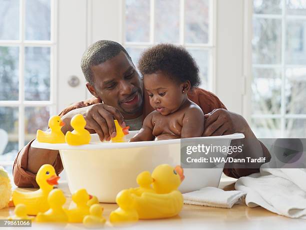 african father bathing baby - baby bathtub 個照片及圖片檔