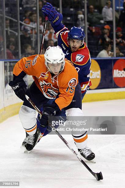 Andy Sertich of the Bridgeport Sound Tigers is chased down by Radek Smolenak of the Norfolk Admirals while controlling the puck during the third...