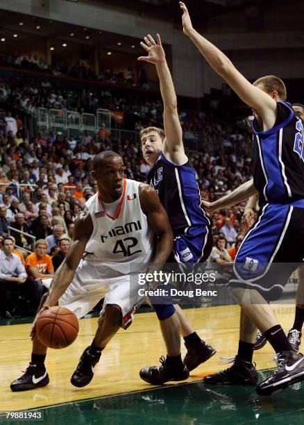 Raymond Hicks of the Miami Hurricanes drives around Greg Paulus and Taylor King of the Duke Blue Devils at BankUnited Center on February 20, 2007 in...