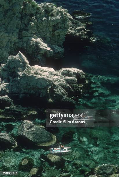 Two couples out rowing off the coast of Sicily near Taormina, 1975.