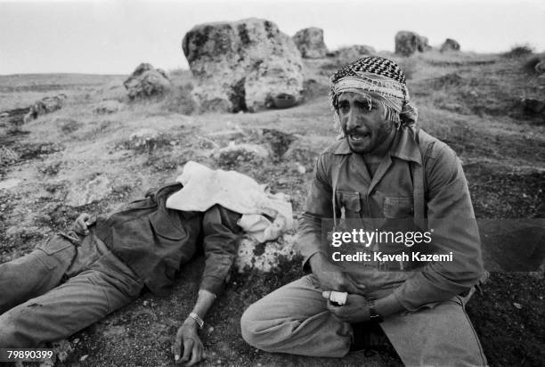 An Iranian Revolutionary Guard weeps by the body of his brother on Kooreh-Moosh height during heavy shelling by Iraqi forces at Sare Pole Zahab,...