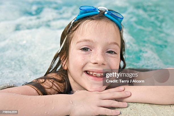 cute 8 year old girl in a whirlpool with swim goggles. - girls in hot tub - fotografias e filmes do acervo