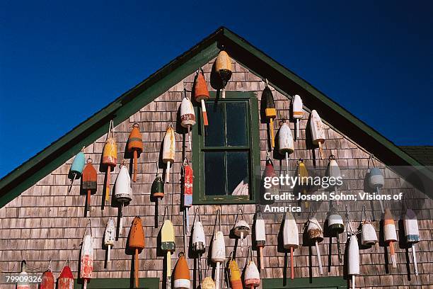 fishing floats hanging on building - ニューハーバー ストックフォトと画像