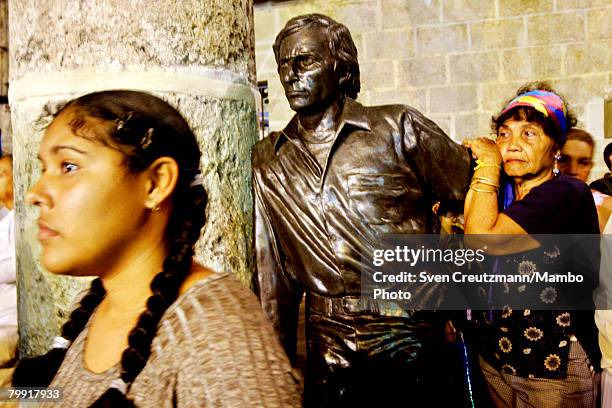 People stand next to a bronze monument for fame Spanish Flamenco dancer Antonio Gades during a mass given by Cardinal Tarcisio Bertone, Secretary of...