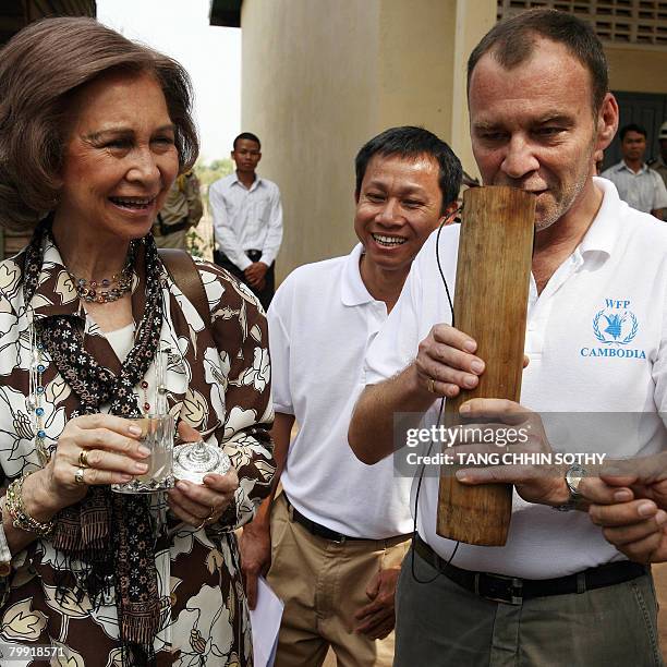 Queen Sofia of Spain and Thomas Keusters , country director of World Food Program , prepare to test a palm drink at Wat Run primary school in Banteay...