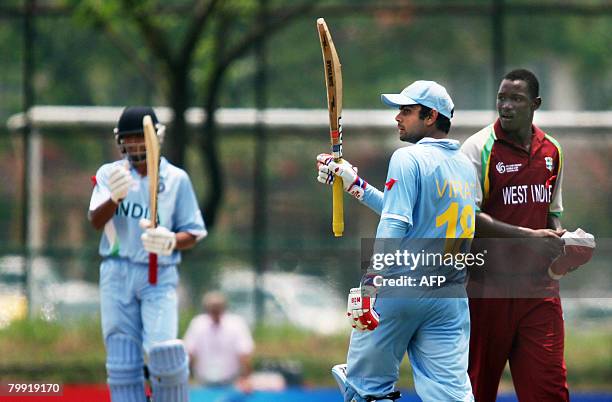 Indian Captain Virat Kohli celebrates his century against the West Indies in the last qualifying match at the Kinrara Cricket Oval in Kuala Lumpur on...