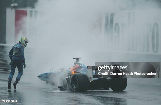 Giancarlo Fisichella of Italy, driver of the Mild Seven Benetton Playlife Benetton B198 Playlife GC37-01 V10 surveys the damage and flames coming...