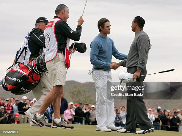 Aaron Baddeley, center, congratulates Tiger Woods, right, after the third-round matches of the WGC-Accenture Match Play Championship at The Gallery...