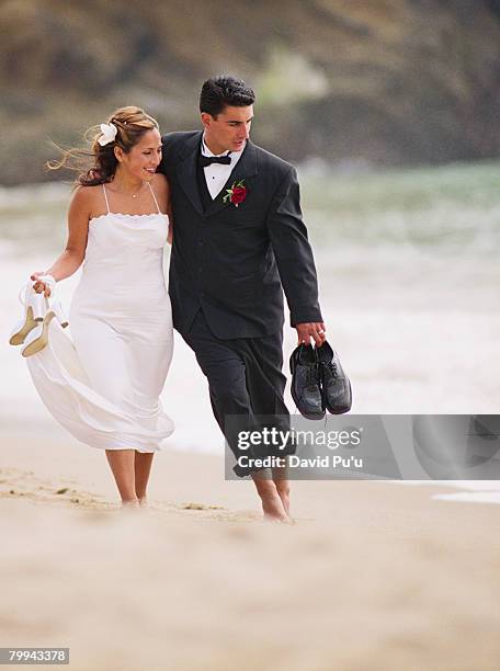 bride and groom walking on beach - david puu stockfoto's en -beelden