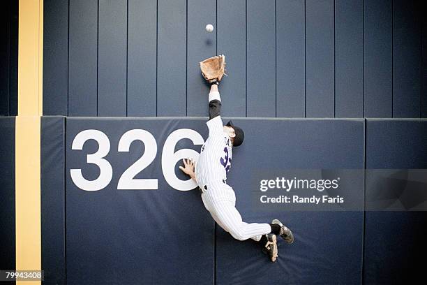 baseball outfielder leaping for fly ball - cuadrangular fotografías e imágenes de stock