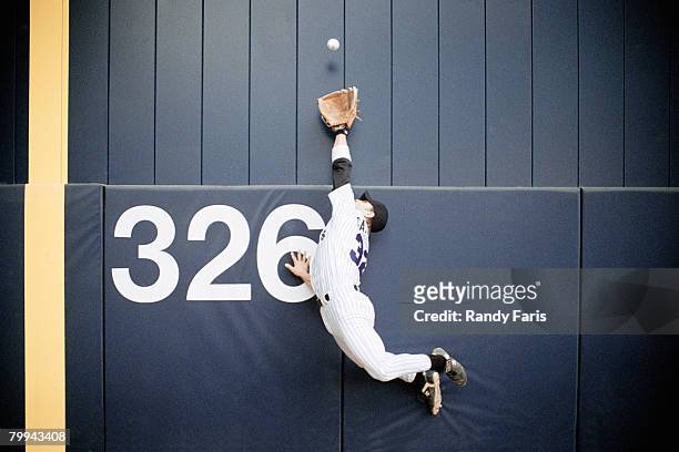 baseball outfielder leaping for fly ball - home run stock pictures, royalty-free photos & images