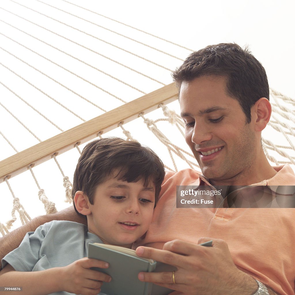 Father and Son Reading in Hammock