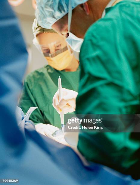 cosmetic surgeon using cauterizing cutter - cauterizing stock pictures, royalty-free photos & images