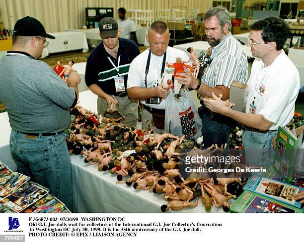 Collectors go through a pile of old G.I. Joe dolls at the International G.I. Joe Collector's Convention in Washington DC July 30, 1999. It is the...
