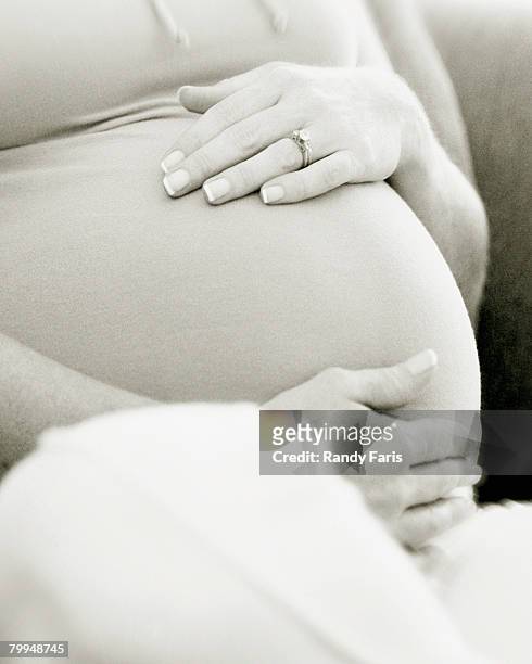 pregnant woman touching stomach - belly ring fotografías e imágenes de stock