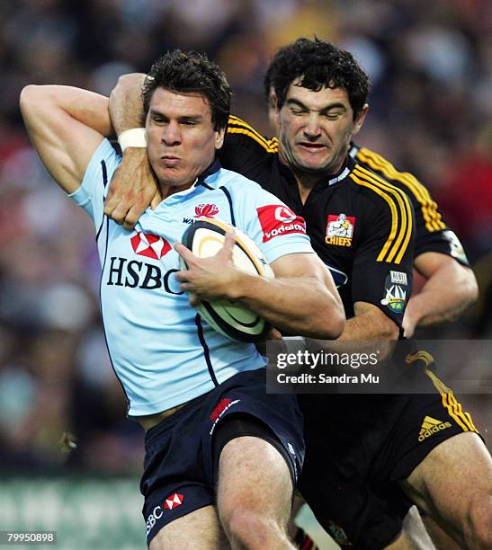 Stephen Donald of the Chiefs tackles Ben Jacobs of the Waratahs during the round two Super 14 match between the Chiefs and the NSW Waratahs at...