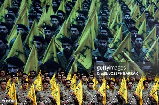 Shiite Muslims Hezbollah militants stand to attention as hundreds of people gather in a huge hall waiting to watch a televised speech by Hassan...