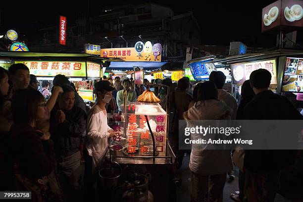 Vendor sells traditional snacks at a night market on February 22, 2008 in Taipei. Taiwan was ceded by imperial China to Japan in 1895 and remained...
