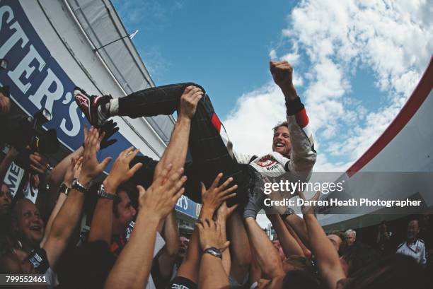 Jenson Button of Great Britain and driver of the Lucky Strike Honda Racing F1 Team Honda RA106 Honda RA806E V8 is lifted in the air by fellow team...