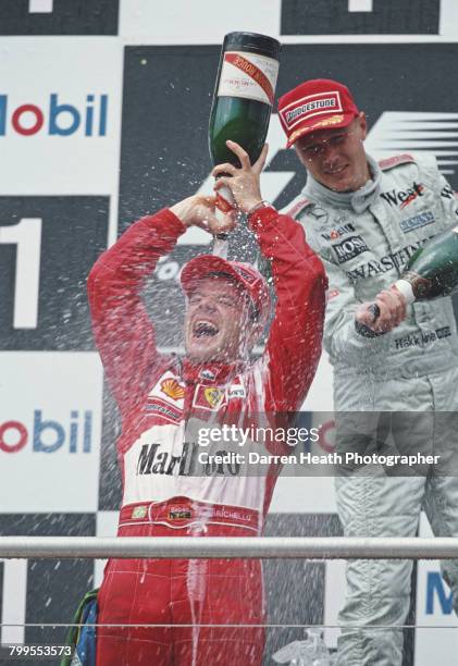 Rubens Barrichello of Brazil, driver of the Scuderia Ferrari Marlboro Ferrari F1-F2000 Ferrari V10 pours Mumm Cordon Rouge Champagne over himself as...