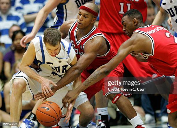 Eugene Lawrence and Anthony Mason Jr. #2 of the St. John's Red Storm reach for a steal against Jon Scheyer of the Duke Blue Devils during the second...