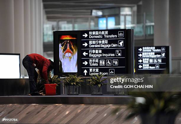 Chinese worker cleans the area beside the baggage conveyor belts at the new Terminal 3 of the Beijing Capital International Airport in Beijing on...