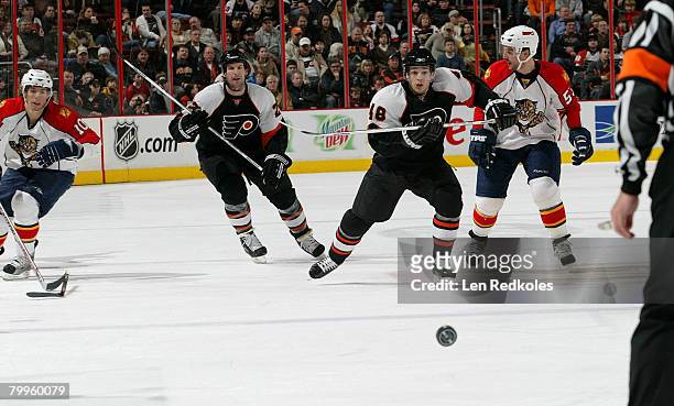 Danny Briere and Mike Knuble of the Philadelphia Flyers skate after the puck against David Booth and Brett McLean of the Florida Panthers on February...