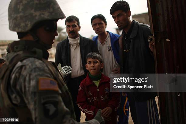 An interpreter with the U.S. Army 501st M.P. Company 1st Armored Division speaks with members of the public about their security concerns in a joint...