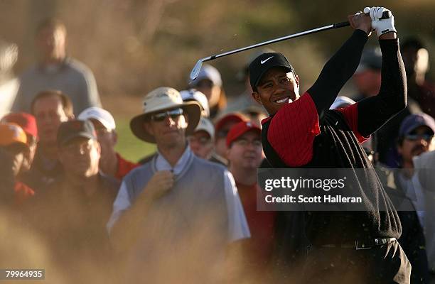 Tiger Woods hits a shot from the rough on the first hole during the Championship match of the WGC-Accenture Match Play Championship at The Gallery at...