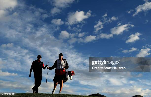Tiger Woods walks off the first green with his caddie Steve Williams during the Championship match of the WGC-Accenture Match Play Championship at...