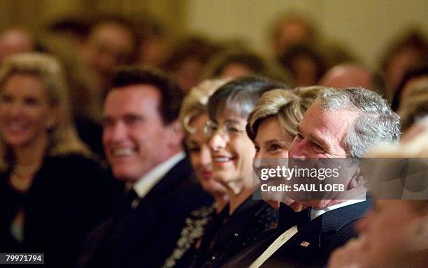 President George W. Bush and First Lady Laura Bush watch as singers Vince Gill and Amy Grant perform in the East Room following a State Dinner for US...