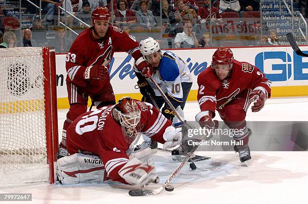 Goaltender Ilya Bryzgalov of the Phoenix Coyotes dives for a loose puck as teammate Keith Ballard gets his stick on it while coyotes defenseman Derek...