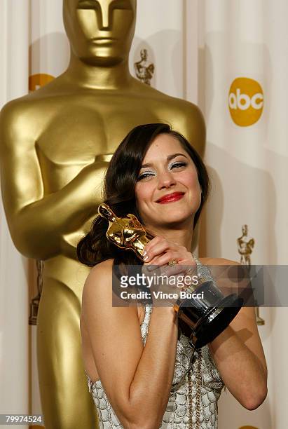 Actress Marion Cotillard, winner of the Performance By An Actress In A Leading Role award for "La Vie en Rose" poses in the press room during the...