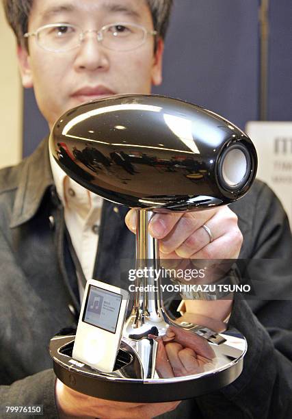 Japanese electronics giant Hitachi's subsidiary Hitachi Maxell employee Kazunori Kuroda displays the rugby ball shaped speaker "MXSP-4000.TD" with...