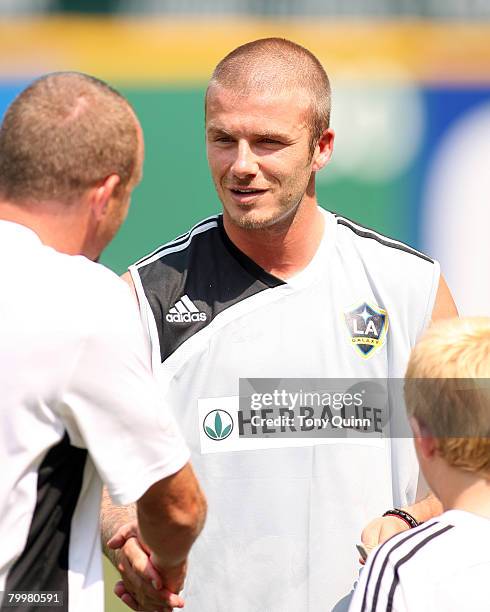 David Beckham greets DC United coach Tommy Soehn and his son during a light training session at RFK stadium on August 8, 2007 in Washington, DC....