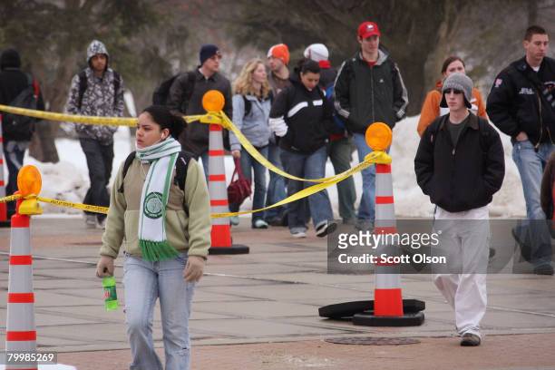 Students make their way around police tape surrounding Cole Hall as they walk to class at Northern Illinois University February 25, 2008 in DeKalb,...