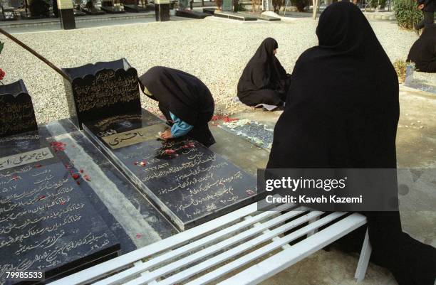 The daughter of a diplomat killed in a Taliban attack on the Iranian Consulate in Mazar Sharif, Afghanistan, cleans her father's tomb in Behesht-e...