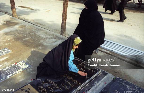 The daughter of a diplomat killed in a Taliban attack on the Iranian Consulate in Mazar Sharif, Afghanistan, cleans her father's tomb in Behesht-e...