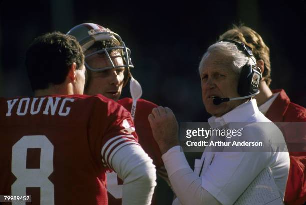 San Francisco 49ers head coach Bill Walsh talks to quarterback Joe Montana and backup quarterback Steve Young --all members of the Pro Football Hall...