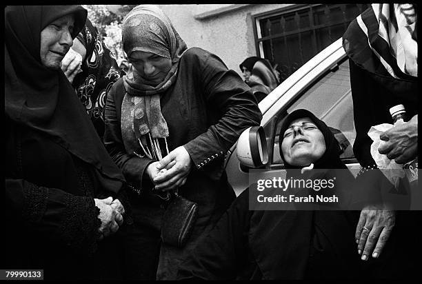 Mourners grieve during a mass funeral service on August 18, 2006 in Qana, southern Lebanon. Many of those buried Friday were killed in an Israeli...