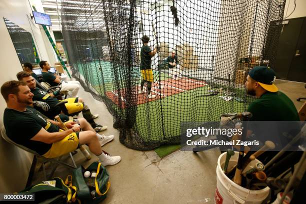 Stephen Vogt, Josh Phegley and Trevor Plouffe of the Oakland Athletics sit at the indoor batting cage prior to the game against the Toronto Blue Jays...