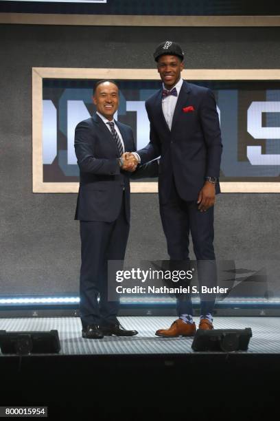 Jaron Blossomgame shakes hands with Deputy Commissioner Mark Tatum after being selected number fifty ninth overall by the San Antonio Spurs during...