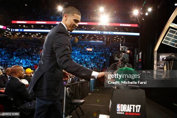 Jayson Tatum picks up his Boston Celtics cap after being selected third at the 2017 NBA Draft on June 22, 2017 at Barclays Center in Brooklyn, New...