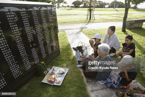 People pray in front of the Cornerstone of Peace at the Peace Memorial Park in the Okinawa city of Itoman on June 23 the 72nd anniversary of the end...