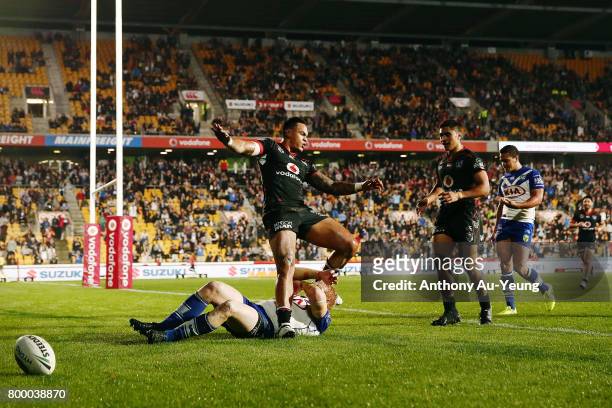 Ken Maumalo of the Warriors celebrates after scoring a try against James Graham of the Bulldogs during the round 16 NRL match between the New Zealand...