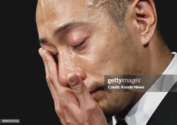 Japanese kabuki star Ichikawa Ebizo wipes away tears during a press conference in Tokyo on June 23 after his wife Mao Kobayashi, a 34-year-old...