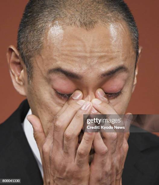 Japanese kabuki star Ichikawa Ebizo wipes away tears during a press conference in Tokyo on June 23 after his wife Mao Kobayashi, a 34-year-old...